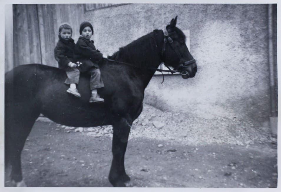 Старая чёрно-белая фотография: двое детей сидят на лошади